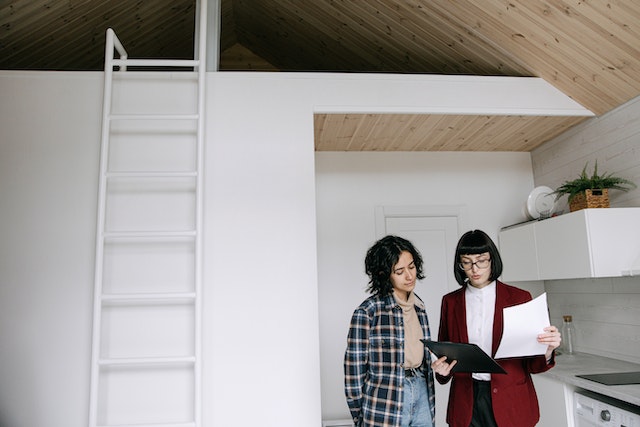 landlord in red jacket showing a tenant a lease agreement containing rental rules and policies